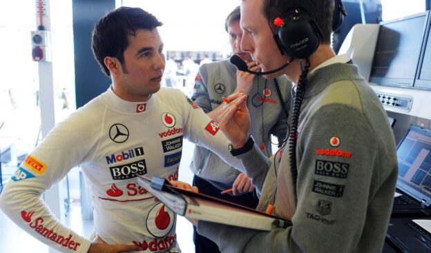 Sergio Perez talks to engineers in the garage