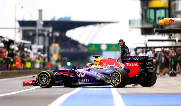 Sebastian Vettel driving out of the Red Bull pit box