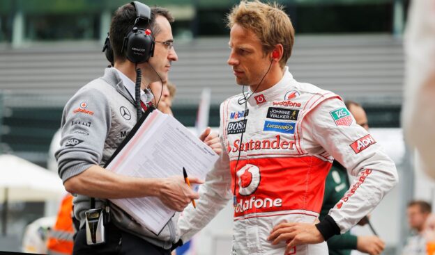 Jenson Button talks with engineer Dave Robson on the grid