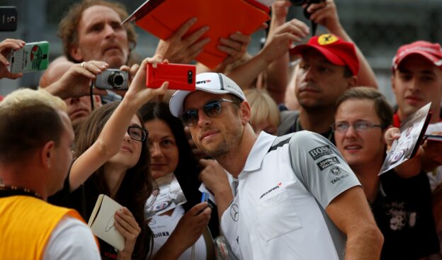 Jenson Button poses for a picture with fans.