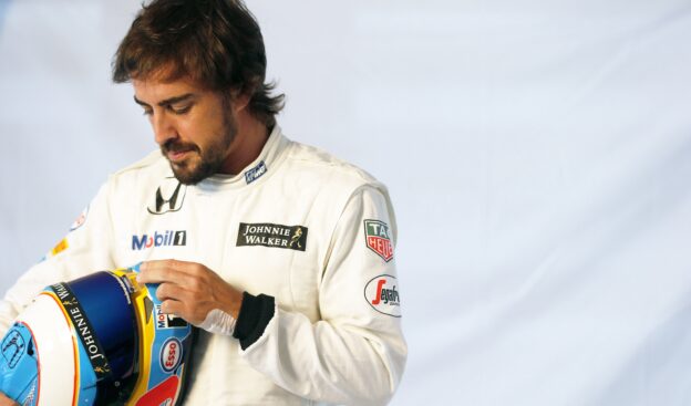 Fernando Alonso prepares his helmet in the garage.