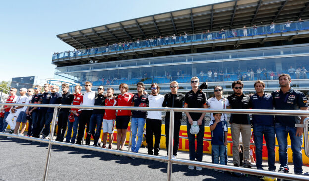 The drivers observe a minute's silence for the late racing driver Justin Wilson in the pit lane before the race