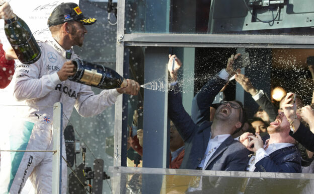 Lewis Hamilton spraying wine at F1 fans on the podium