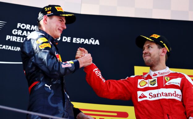 Max Verstappen is congratulated on his first F1 win on the podium by Sebastian Vettel