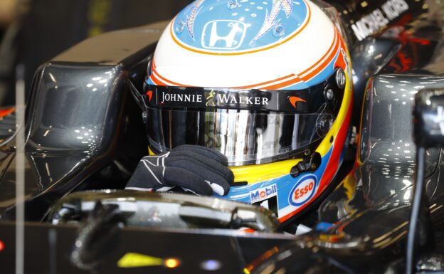 Fernando Alonso adjusts his visor in the cockpit.