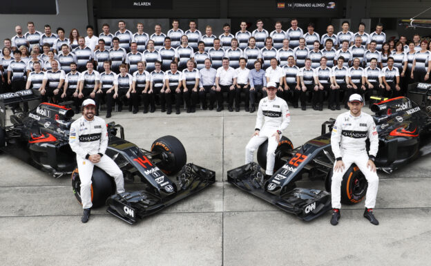 A team group photo. Fernando Alonso, Stoffel Vandoorne and Jenson pose with their McLaren MP4-31 Hondas in front of the assembled team.