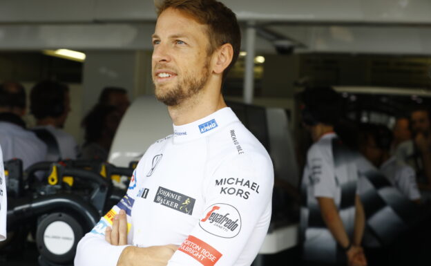 Jenson Button stands in front of the garage.